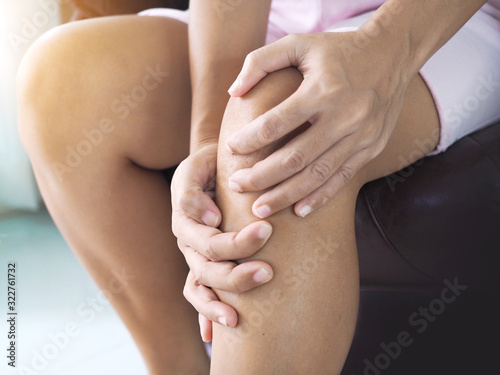 Close-up of Asian women with knee and leg pain By using hands to massage body to relieve pain