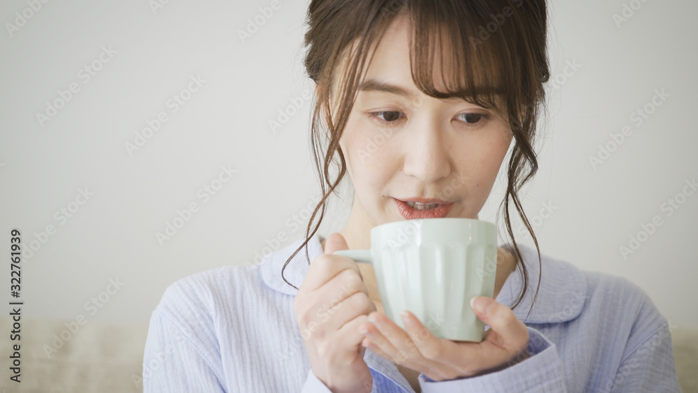 パジャマ姿でマグカップを持つ女性 パジャマ姿でマグカップを持つ女性