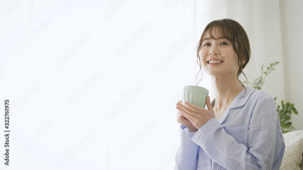 パジャマ姿でマグカップを持つ女性