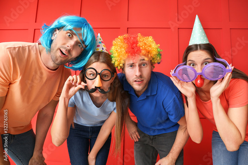 People in funny disguise on color background. April fools  day celebration