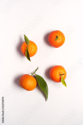 Overhead View Of Fresh Satsumas With Leaves Against White Background