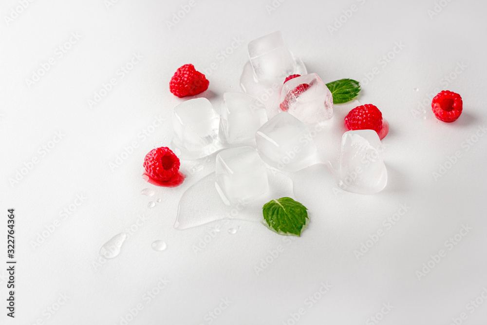 Ice cubes with raspberries and mint leaf on wooden table. Homemade skincare hydrating ice cubes. Close up, copy space for text Ice cubes with raspberries and mint leaf on wooden table. Homemade skincare hydrating ice cubes. Close up, copy space for text
