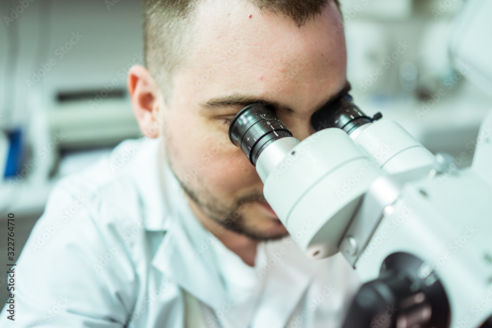 Doctor scientist using microscope in hospital lab Doctor scientist using microscope in hospital lab
