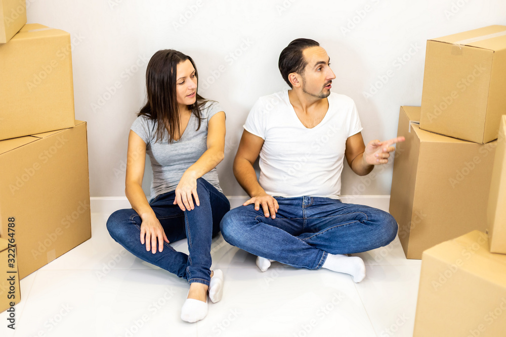 Packed and ready to move in new house. Excited young spouses sitting among carton boxes ready to relocate. Packed and ready to move in new house. Excited young spouses sitting among carton boxes ready to relocate.