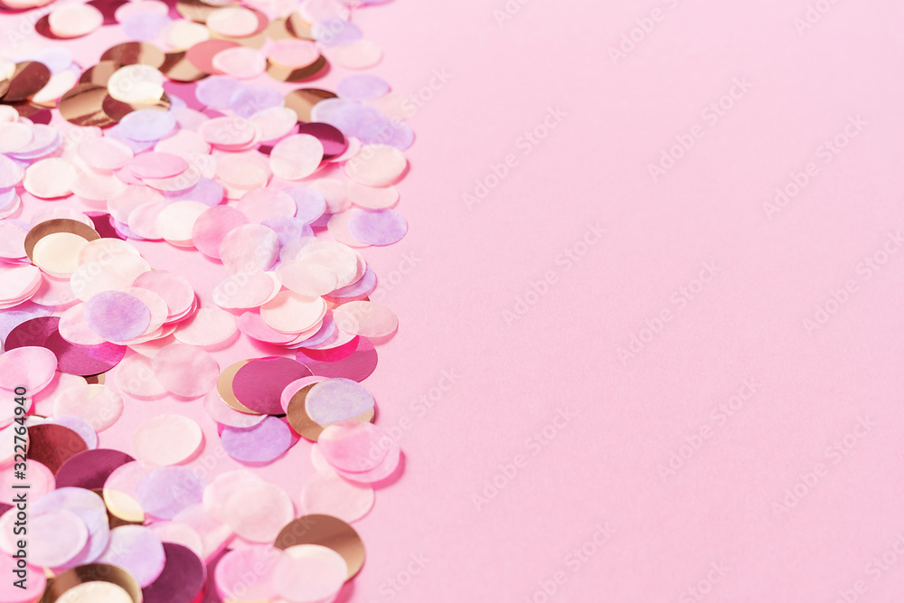 Pastel pink background with colorful round paper confetti. Holiday concept. Flat lay. Backdrop for your design.