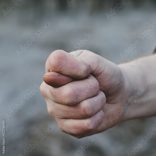 Close-up fig sign. Man right hand shows the fig. Front View Of Fig Sign - Hand Gesture. Eye level shooting. Selective focus. Close-up. photo