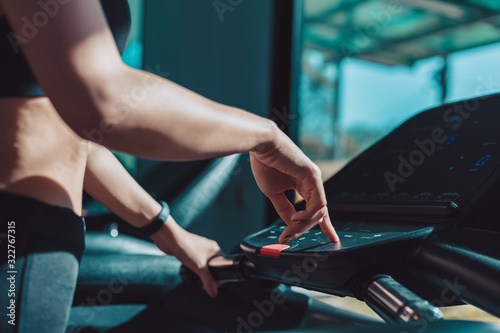 finger pressing on button of running machine in gym