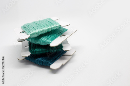 Embroidery floss cross stitch string kit prewound on bobbins for crafts and hobbies. Multicolor thread on cardboard. Embroidery floss on white background