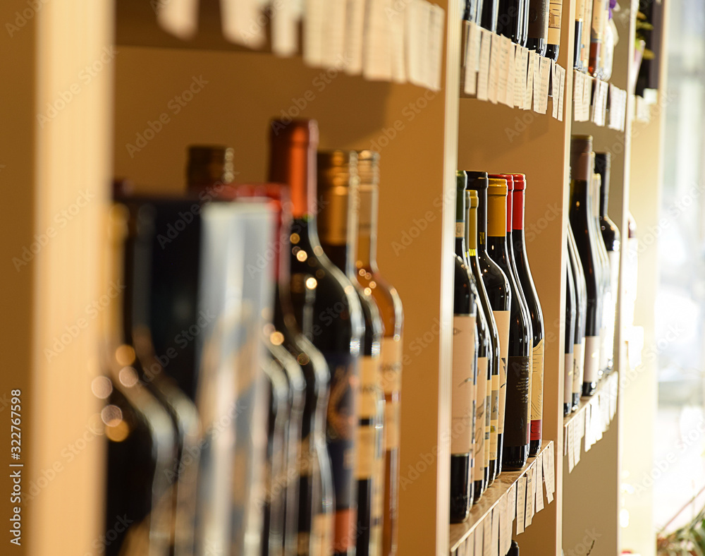 Wine bottles on wooden shelf in wine store Wine bottles on wooden shelf in wine store