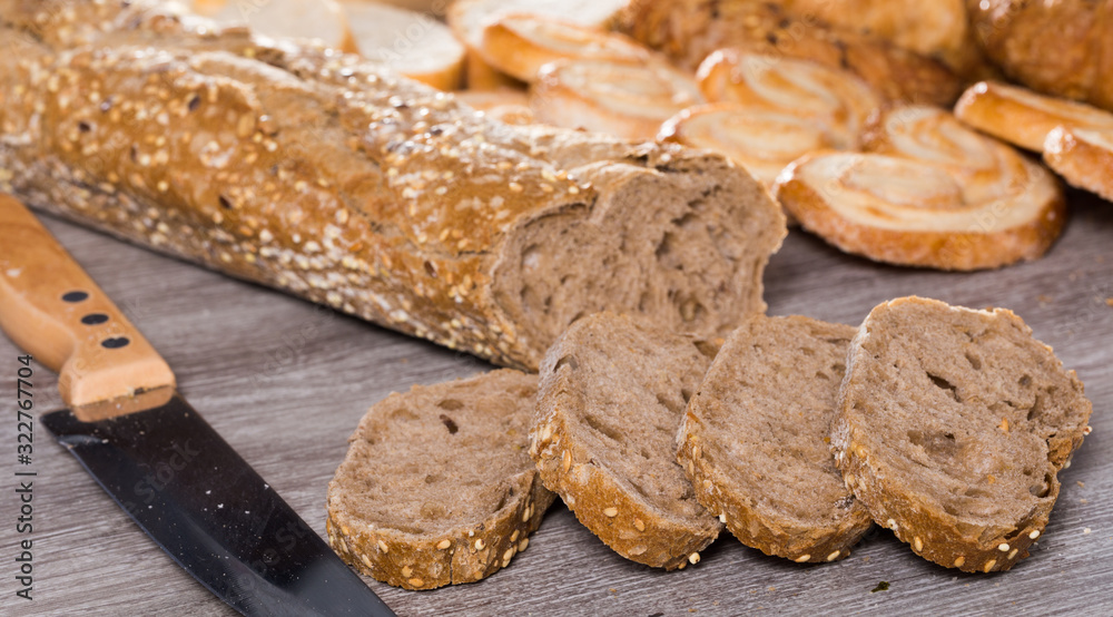 slices of wheaten bread and knife on wooden surface slices of wheaten bread and knife on wooden surface
