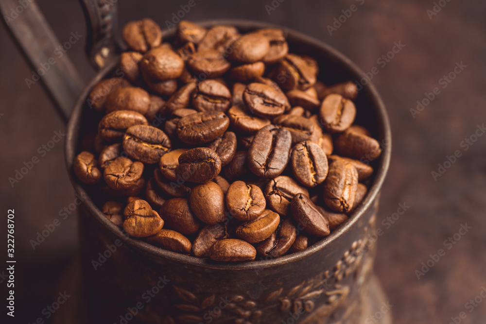 Fototapeta premium Coffee beans on the rustic wooden background. Selective focus. Shallow depth of field.