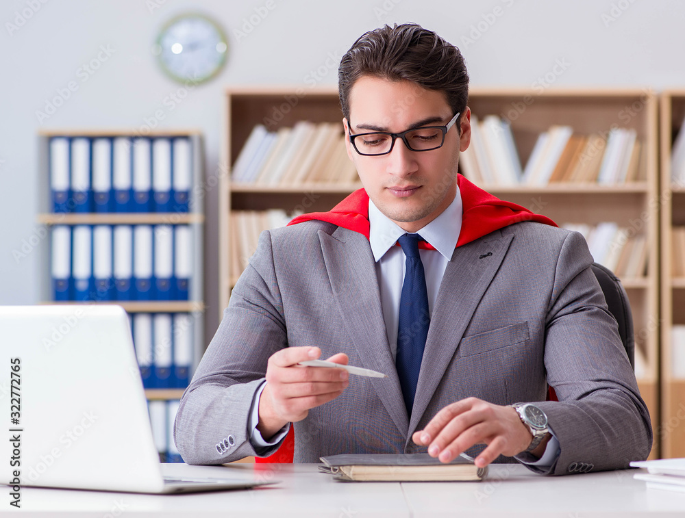 Superhero businessman working in the office Superhero businessman working in the office