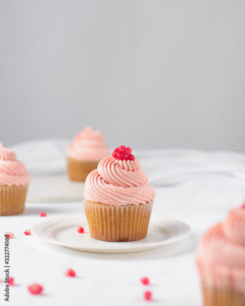 Cupcake with pink buttercream and pomegranate seeds