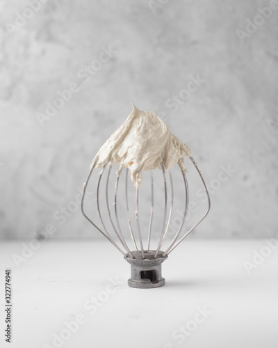 Cream colored american buttercream on a whisk attachment photo