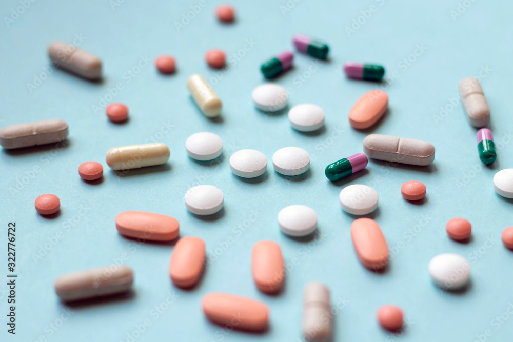 A lot of tablets and pills on blue background, medical treatment, medicine