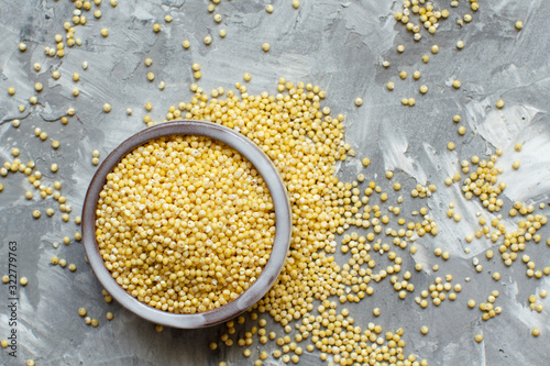 Raw dry hulled millet in a ceramic bowl photo