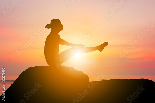 Silhouette of young woman with clipping path practicing yoga relaxing exercise at sunset