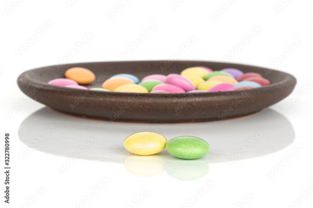Lot of whole sweet colourful candy front focus with brown ceramic coaster isolated on white background Lot of whole sweet colourful candy front focus with brown ceramic coaster isolated on white background