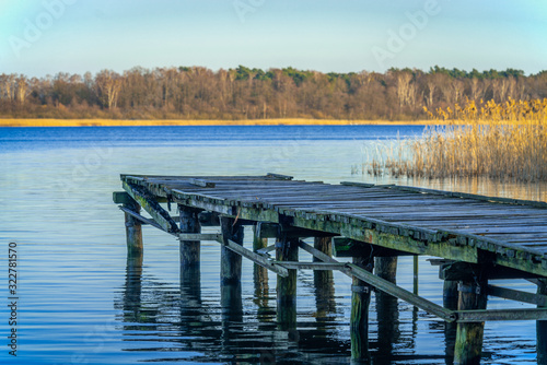 Old wooden landing stage at a tranquil lake © Ina