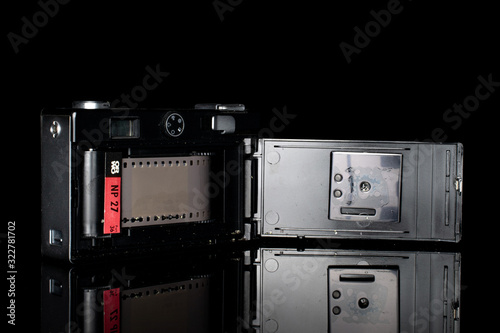 One whole opened vintage camera isolated on black glass photo
