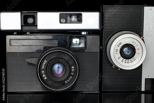 Group of three whole vintage camera closeup isolated on black glass