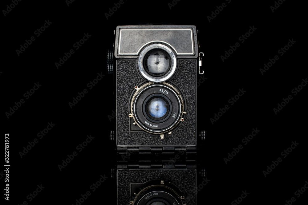 One whole vintage camera isolated on black glass - obrazy, fototapety, plakaty 