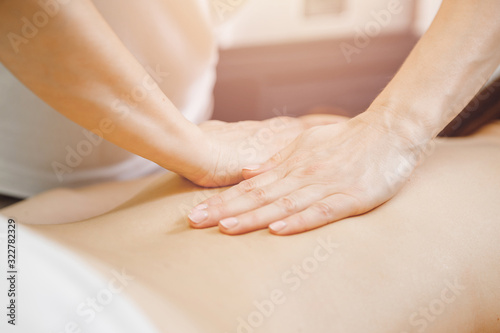Young woman relaxing with hand professional back massage beauty spa