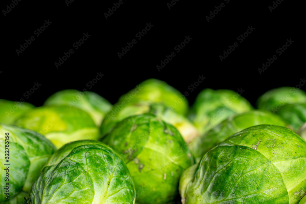 Lot of whole fresh green brussels sprout isolated on black glass Lot of whole fresh green brussels sprout isolated on black glass