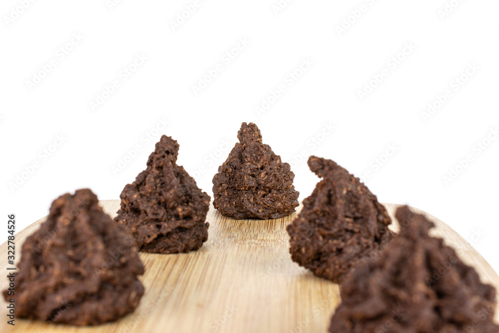 Group of five whole homemade brown coconut cocoa biscuit on bamboo cutting board isolated on white background Group of five whole homemade brown coconut cocoa biscuit on bamboo cutting board isolated on white background