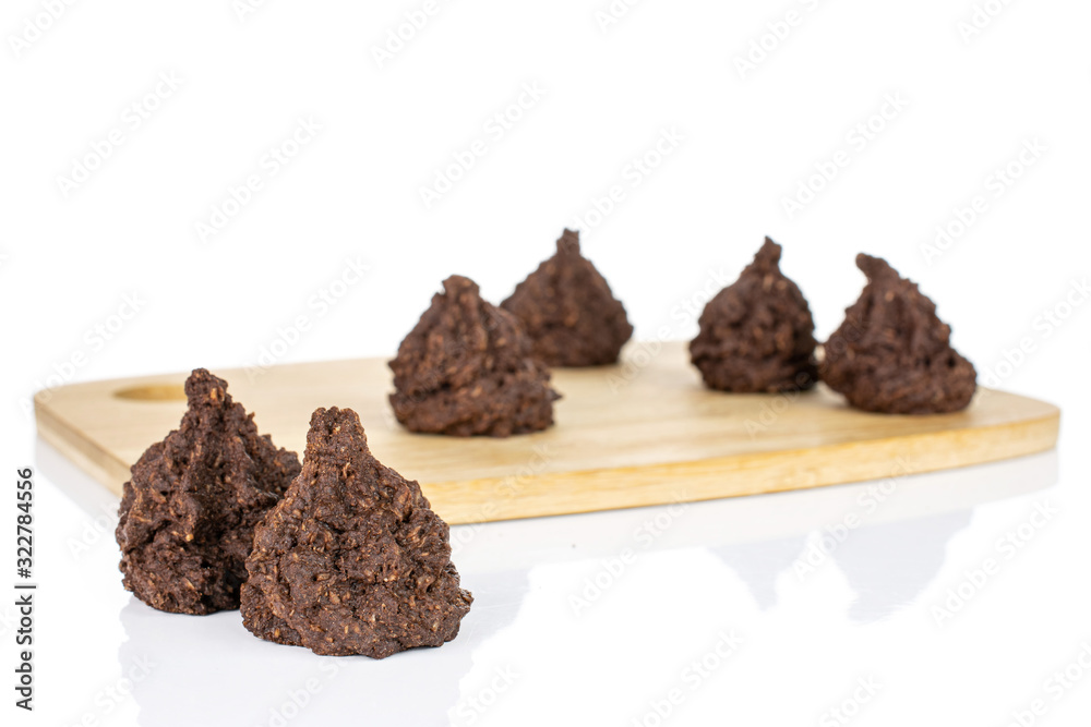 Group of six whole homemade brown coconut cocoa biscuit on bamboo cutting board isolated on white background