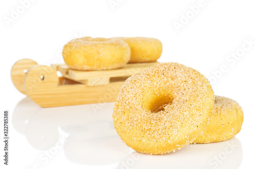 Group of four whole sweet golden mini cinnamon donut with wooden sledge isolated on white background