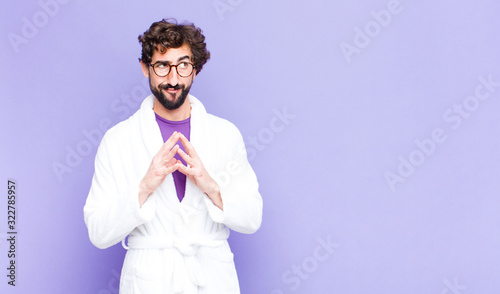young bearded man wearing bathrobe scheming and conspiring, thinking devious tricks and cheats, cunning and betraying
