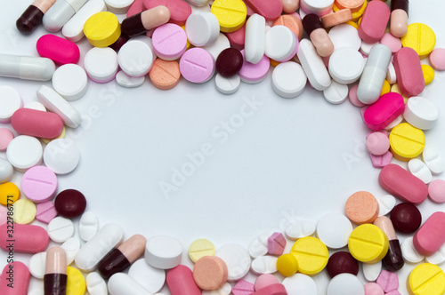 Different colorful drugs or medicine pills tablet supplements for the treatment and health care on a white background. Copy space.