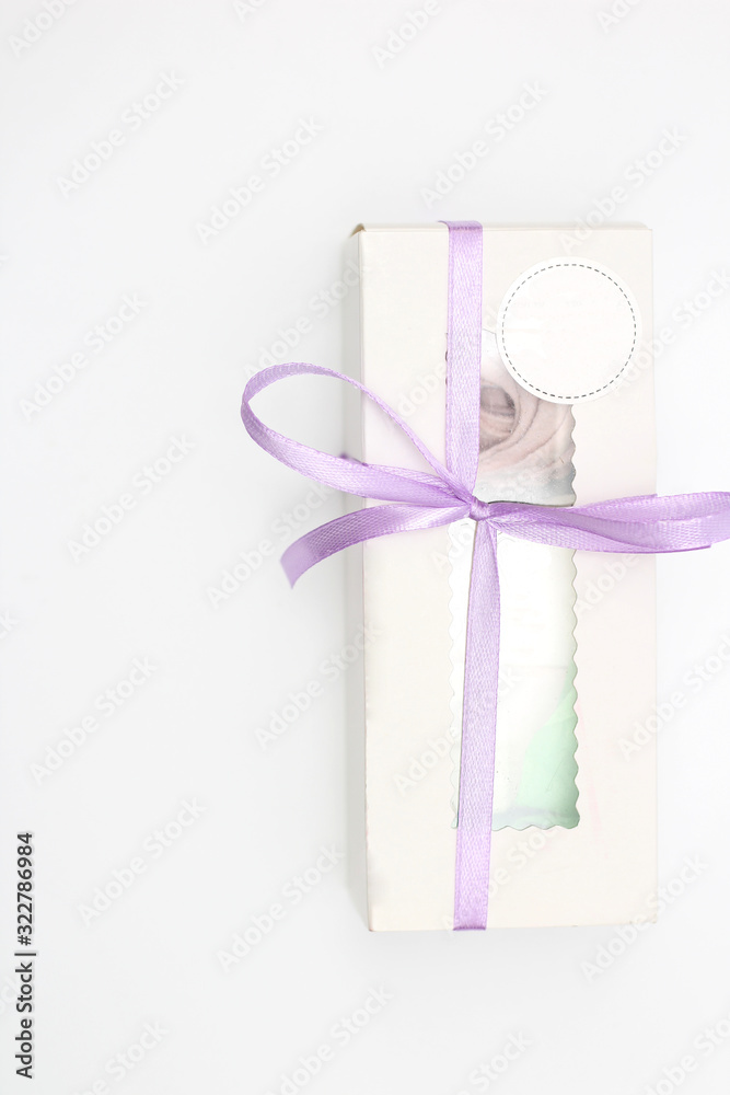 White cardboard box with a transparent top tied with a lilac ribbon isolated on a white background. A wonderful gift for Valentine's Day, birthday. White cardboard box with a transparent top tied with a lilac ribbon isolated on a white background. A wonderful gift for Valentine's Day, birthday.