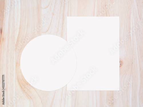 White circle paper and blank white paper on vintage brown wooden background. top view