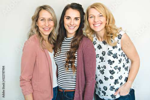Group of friends woman portrait close to a white wall
