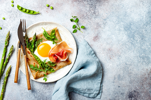 Schilderij op canvas Buckwheat crepes, galette bretonne with asparagus, egg, green pea, jambon or prosciutto