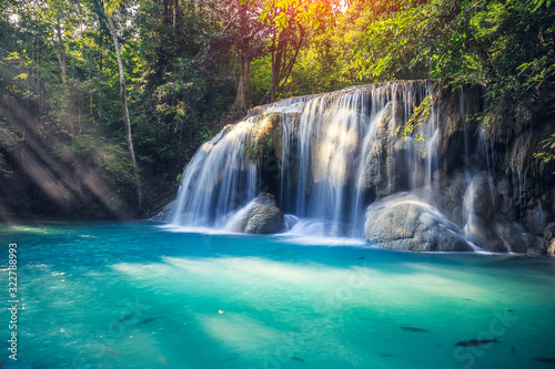 Waterfall, green forest in Erawan National Park, Thailand. Landscape with water flow, river, stream and rock at outdoor. Beautiful scenery of nature for tourist to tour, visit, relax in vacation. © DifferR