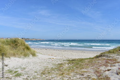 Fototapeta Naklejka Na Ścianę i Meble -  Beach with waves breaking, rocks and grass on sand dunes. Viveiro, Lugo, Galicia, Spain.