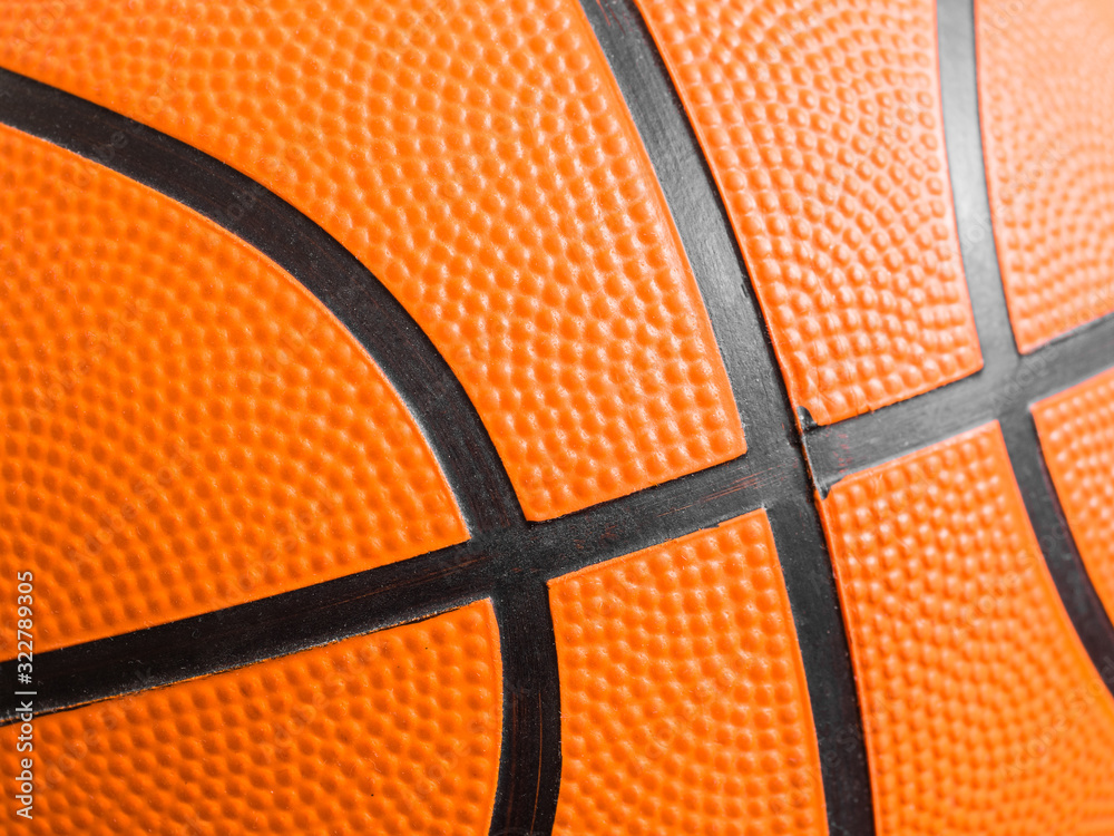 Fototapeta premium Orange basketball ball close up. Fragment, black stripes, texture. Sport geometric background