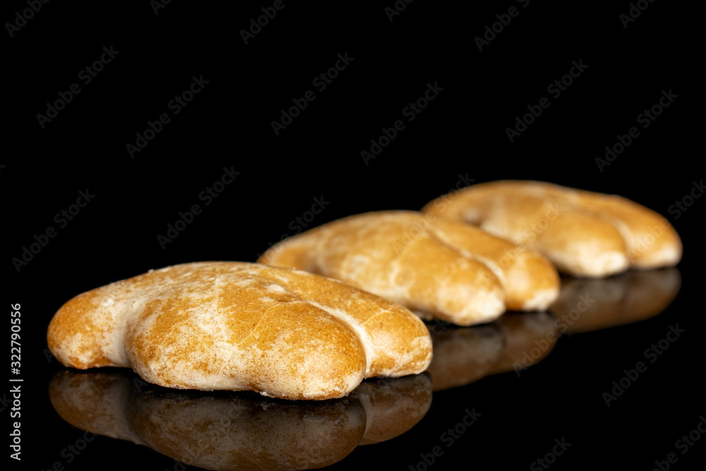 Group of three whole sweet brown gingerbread placed diagonally isolated on black glass