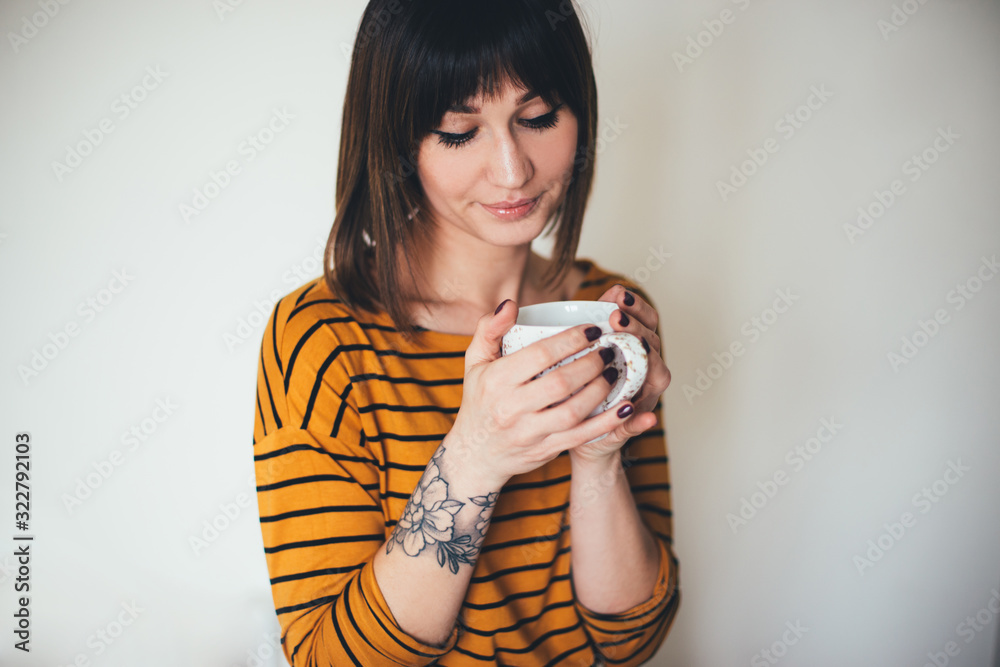 Woman with tattoo drink coffee on white background Woman with tattoo drink coffee on white background
