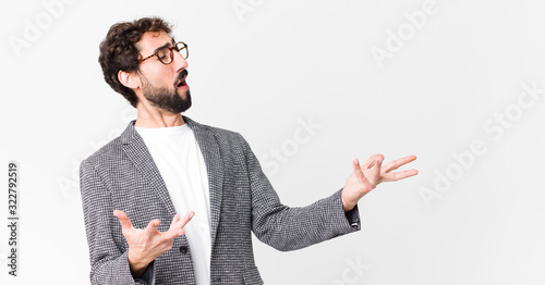 young crazy businessman performing opera or singing at a concert or show, feeling romantic, artistic and passionate against flat wall