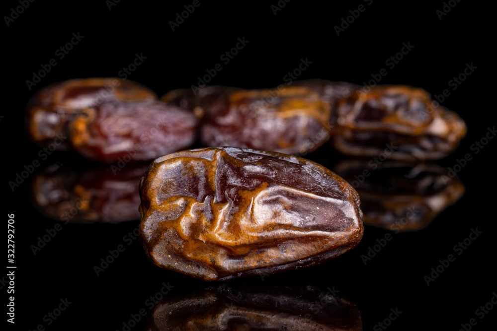Lot of whole dry brown date fruit isolated on black glass Lot of whole dry brown date fruit isolated on black glass