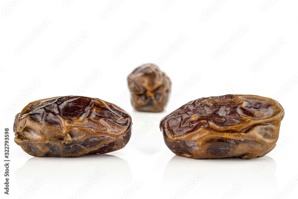 Group of three whole dry brown date fruit isolated on white background Group of three whole dry brown date fruit isolated on white background