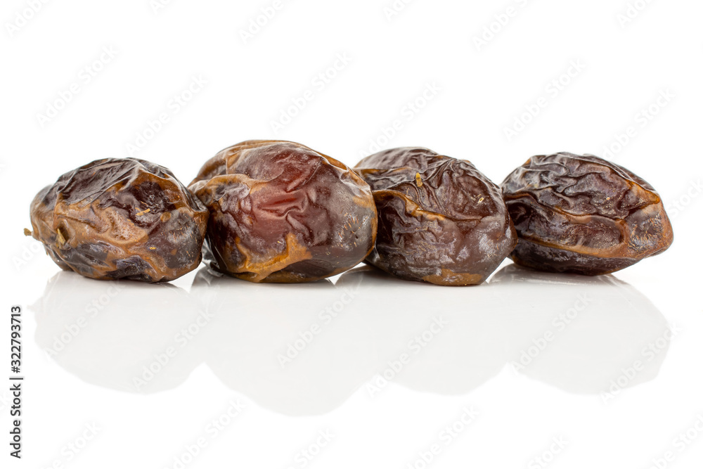 Group of four whole dry brown date fruit isolated on white background Group of four whole dry brown date fruit isolated on white background