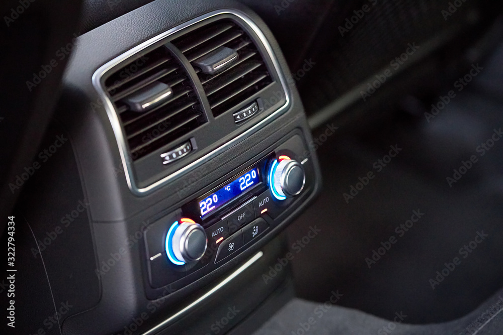 Control panel with digital multi color display and knobs for rear seat passenger in modern prestige luxury car interior selective focus with copy space Control panel with digital multi color display and knobs for rear seat passenger in modern prestige luxury car interior selective focus with copy space