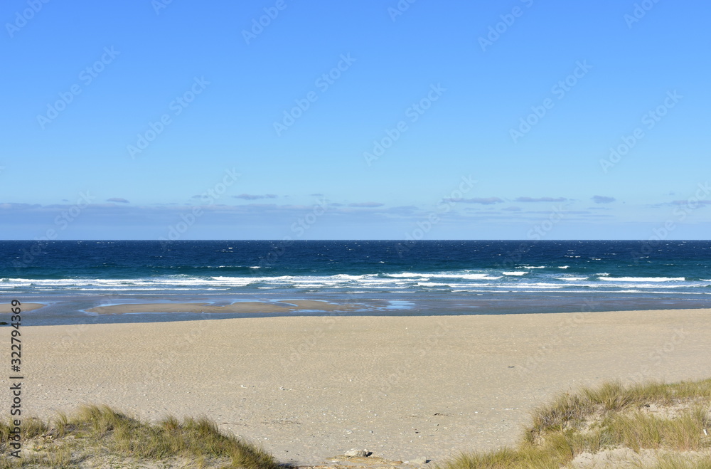 Summer landscape with wild beach with waves breaking and blue sky. Arteixo, Coruña, Galicia, Spain.
