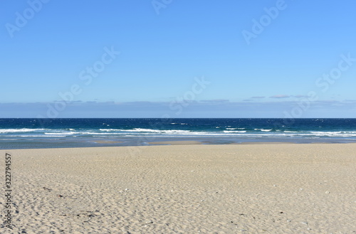 Summer landscape with wild beach with waves breaking and blue sky. Arteixo  Coru  a  Galicia  Spain.