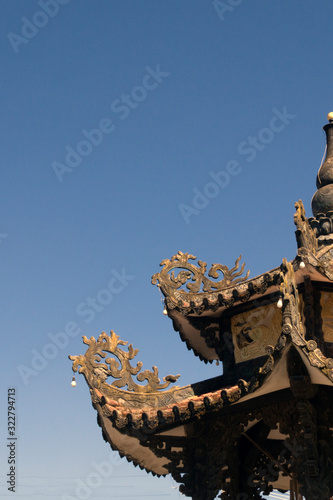 carved roof of a buddhist temple in asia against the sky